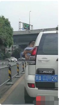 车子行走过程中男孩被抱出车窗外撒尿违章吗?