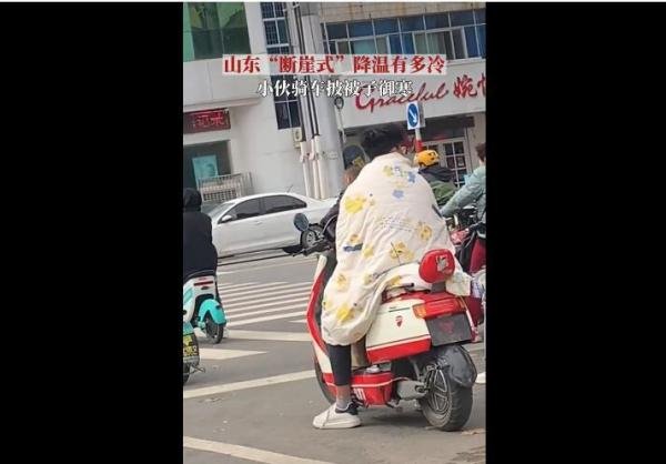 山东断崖式降温 小伙披被子骑车 这是咋情况？