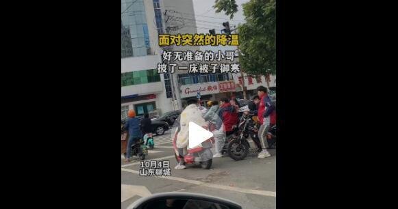 山东断崖式降温 小伙披被子骑车 这是咋情况？